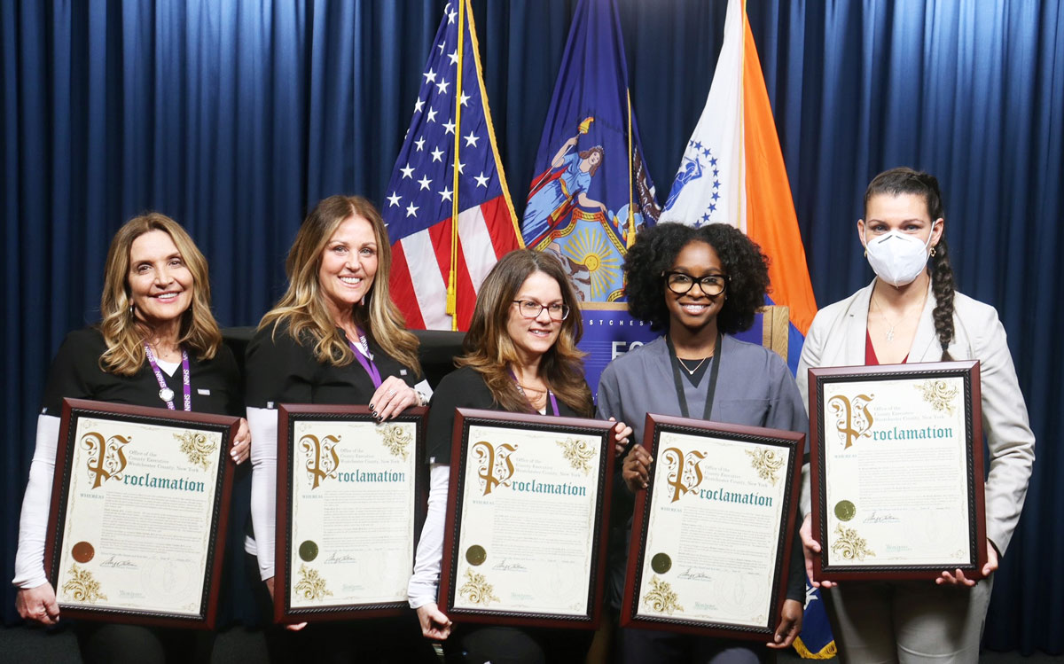 members of the New Rochelle High School nursing team stand together holding framed awards