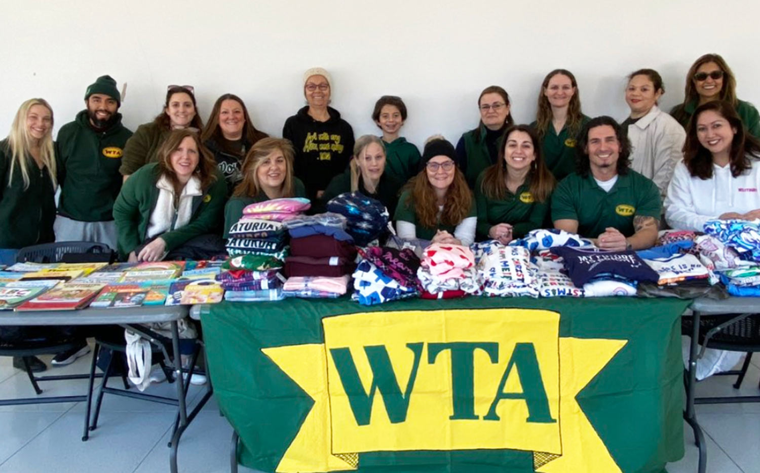 members of the Westbury Teachers Association gather for a group photo at the associations table during a pajama drive