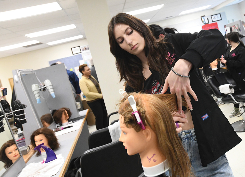 Cosmetology student practicing on training mannequin 