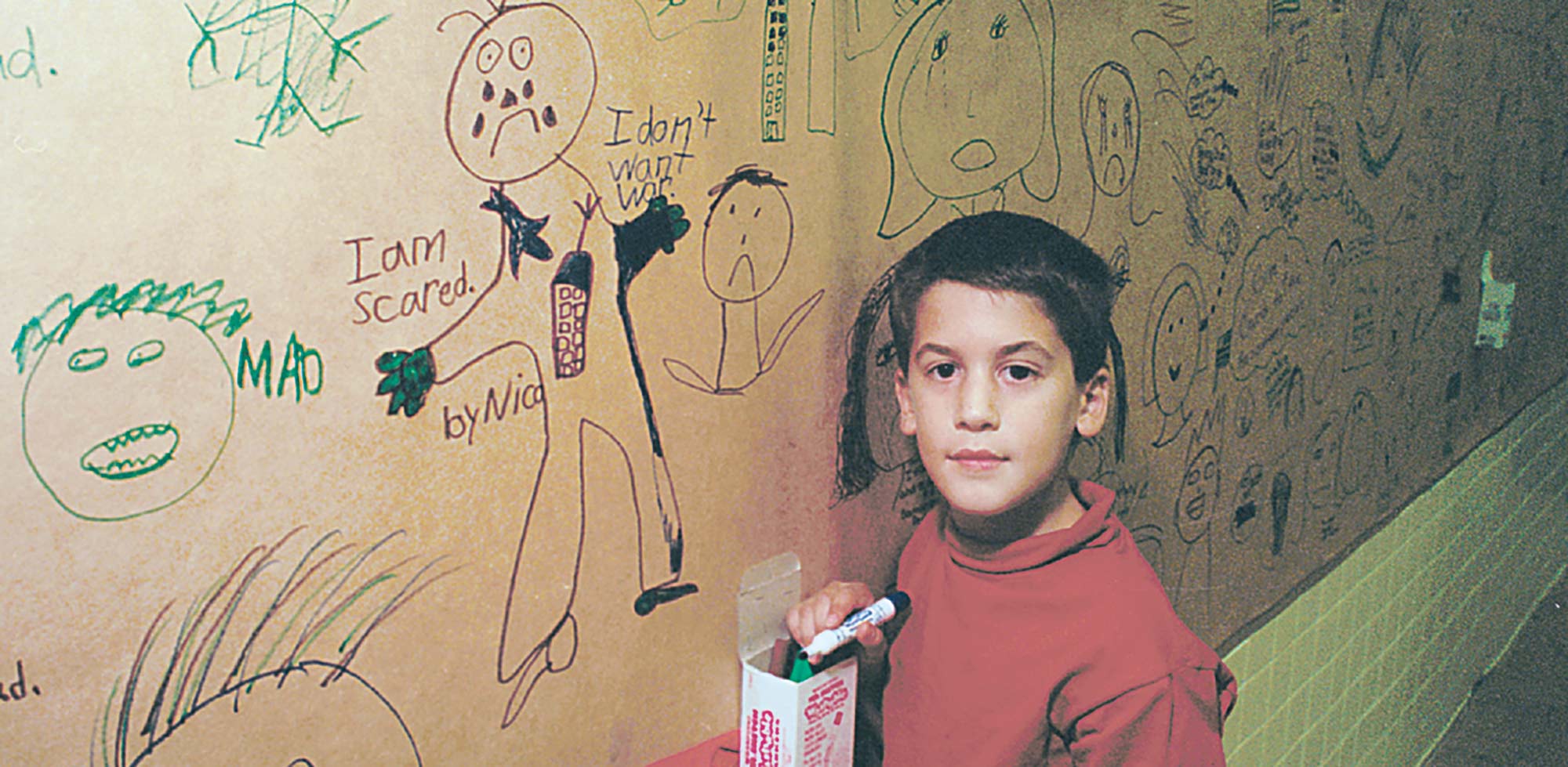 A boy drawing on the wall
