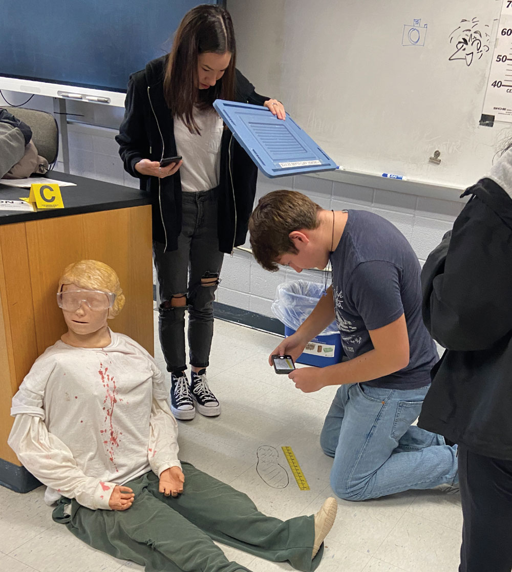 students working on a test dummy in a forensic science course