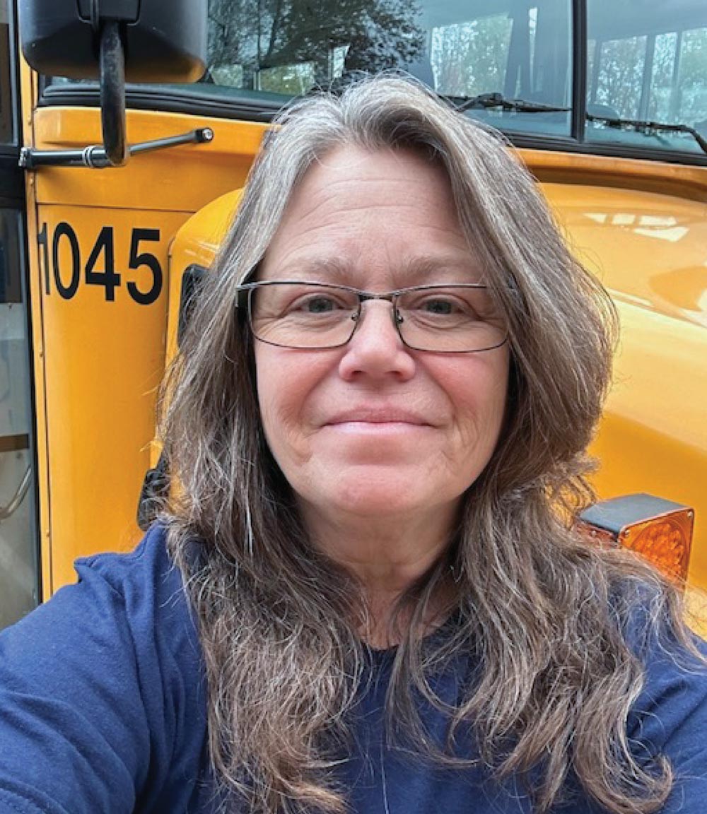 Alicia Schreibman headshot in front of a school bus