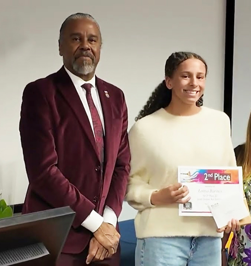J. Philippe Abraham and Lottia Barnes standing next to each other while Lottia Barnes holds an award
