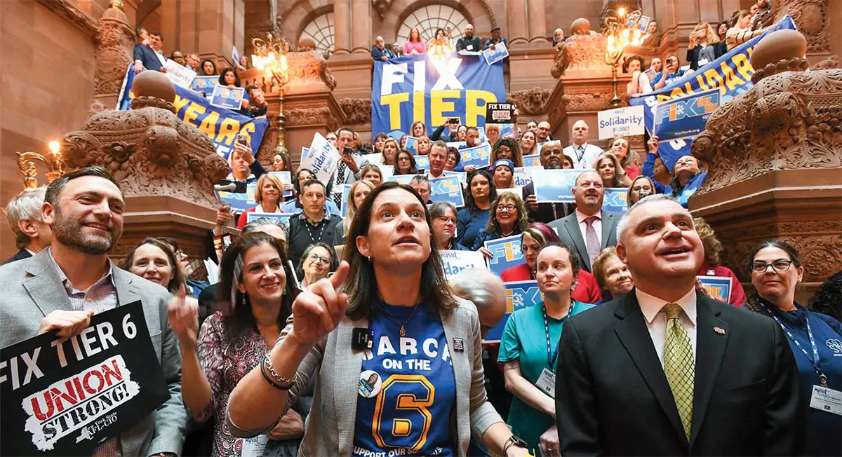 NYSUT President Melinda Person with fellow supporters gathered on the NYS Capitol's Million Dollar Staircase holding union posters