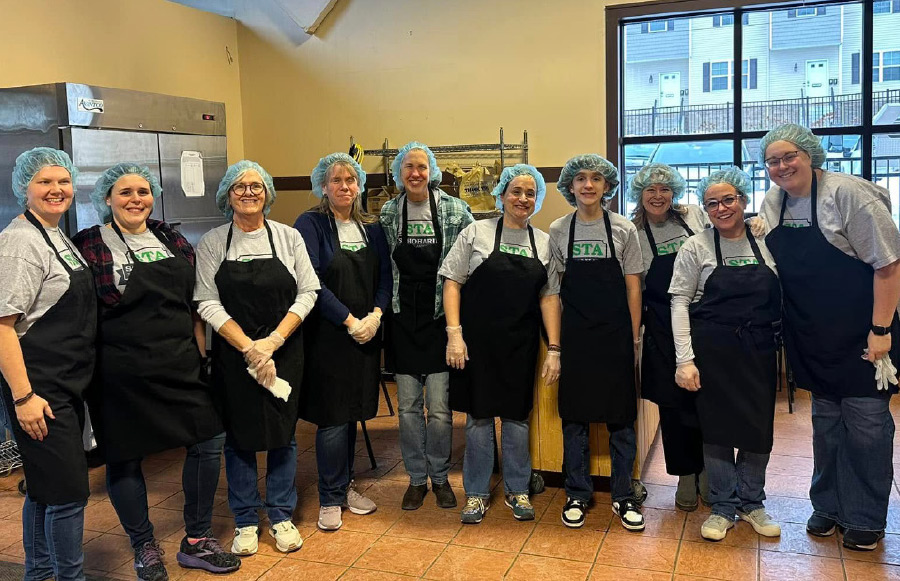 Members of the Schoharie TA in aprons and hair caps smiling for group photo