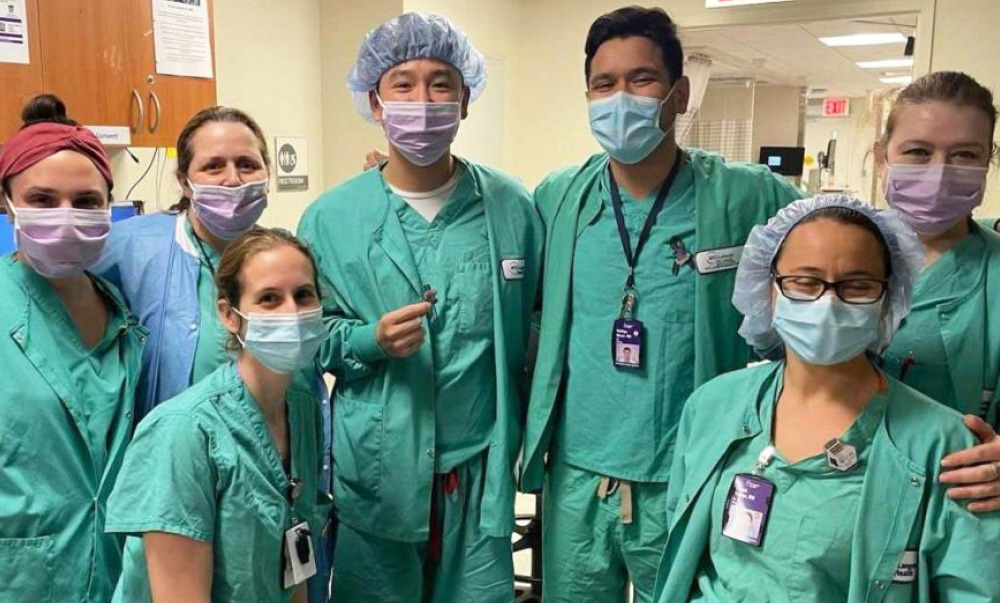 group photo of hospital staff wearing scrubs and face masks 