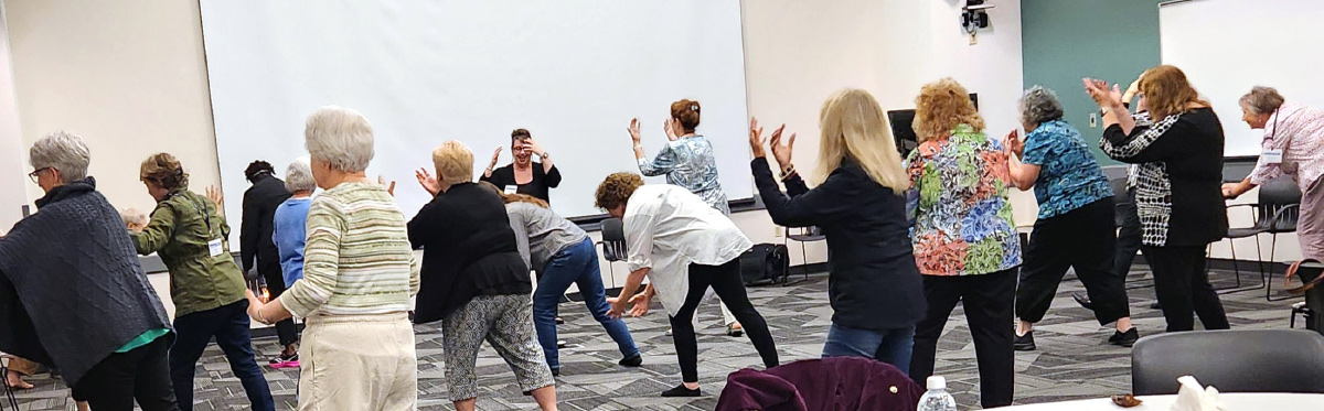 Maria Patrick leading about 30 retirees at the 2025 Spring RC 10 Conference in a Qi Gong session