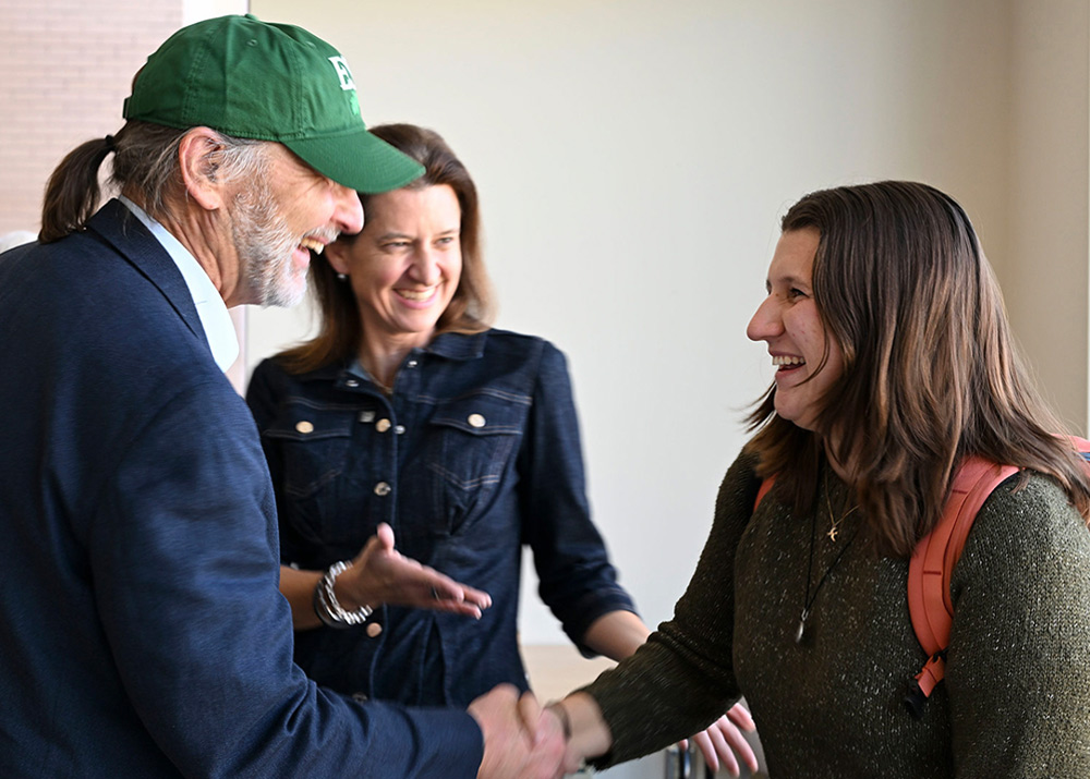 UUP President Fred Kowal shakes a student's hand at SUNY ESF, as NYSUT President Melinda Person smiles in the background.
